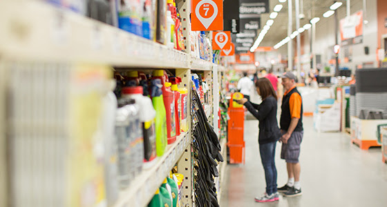 man and woman shopping in aisle of home improvement store